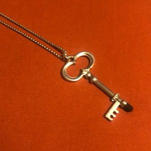 Chico’s long silver chain with key. Rhinestone and black onyx accent